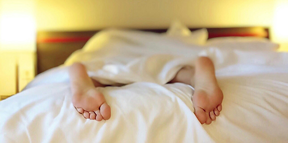 Photo d'une personne épuisé dans son lit.